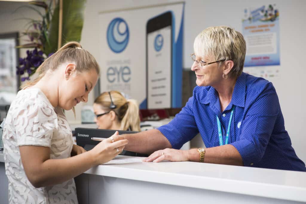 Receptionist at the Queensland Eye Institute speaking to a patient