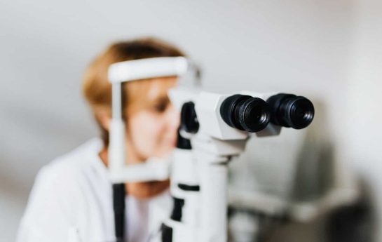 patient looking through lens to determine whether cataracts are needed