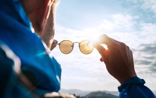 man holding up sunglasses