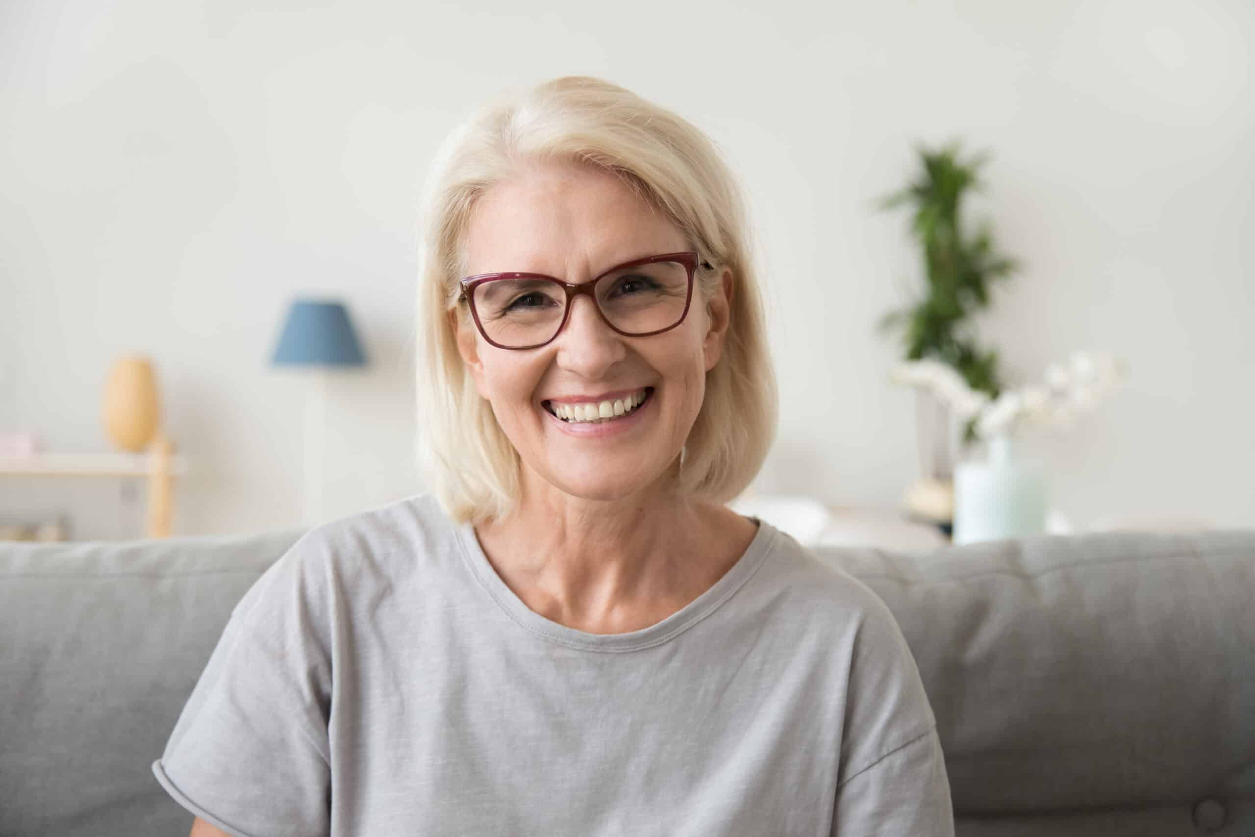 Smiling mature woman looking at the camera getting a glaucoma test completed