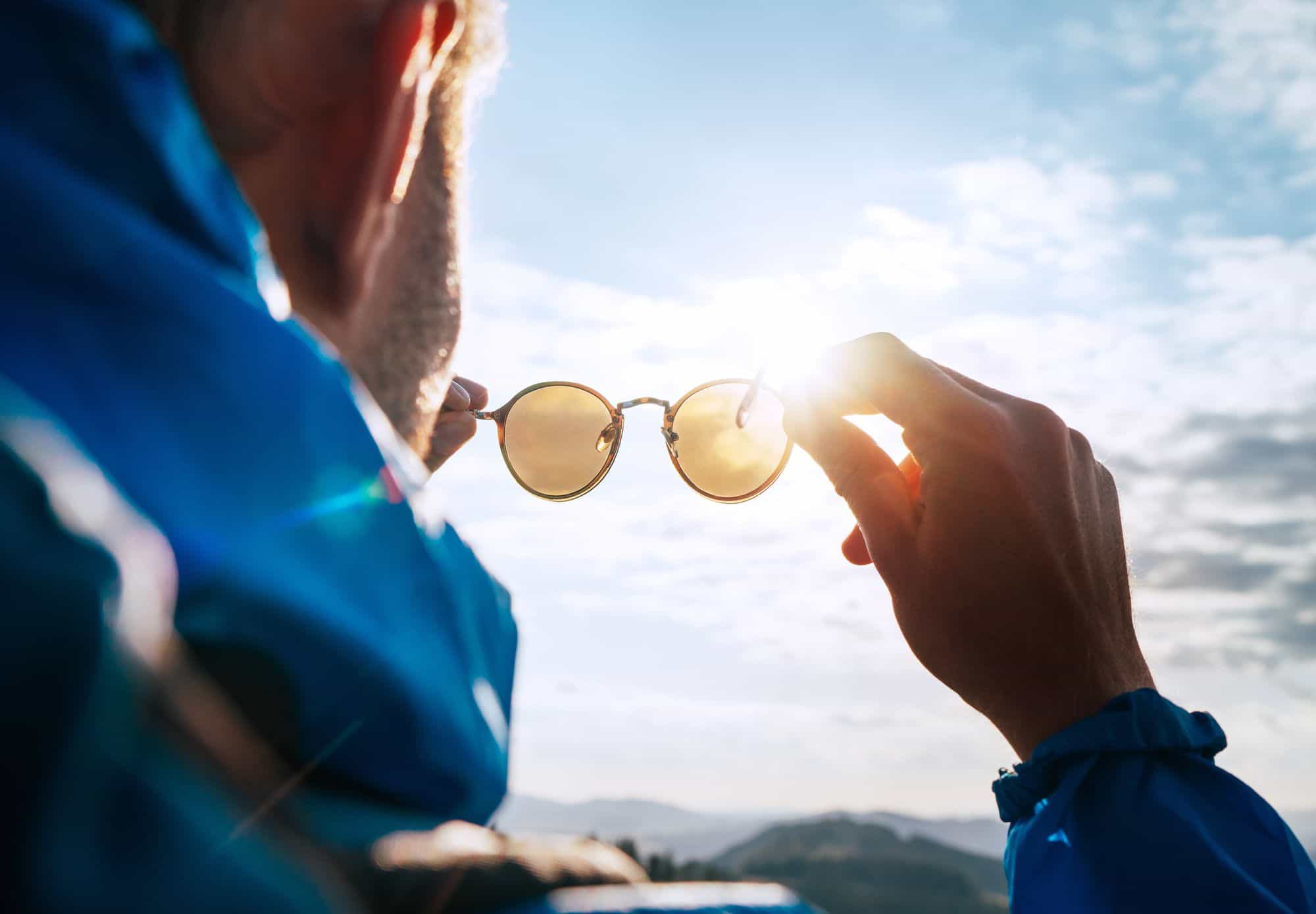 man holding up sunglasses