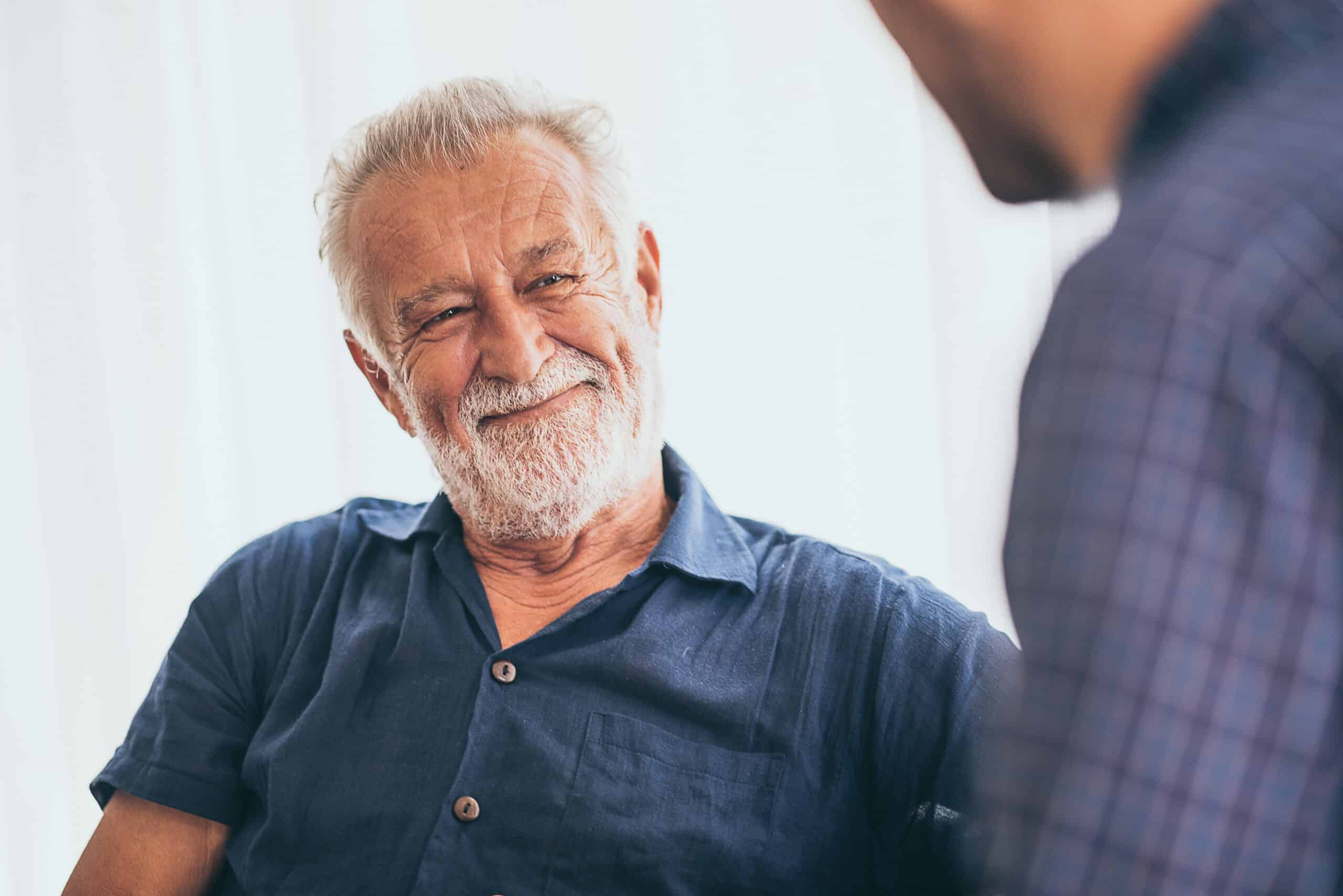 Senior man smiling at a younger man