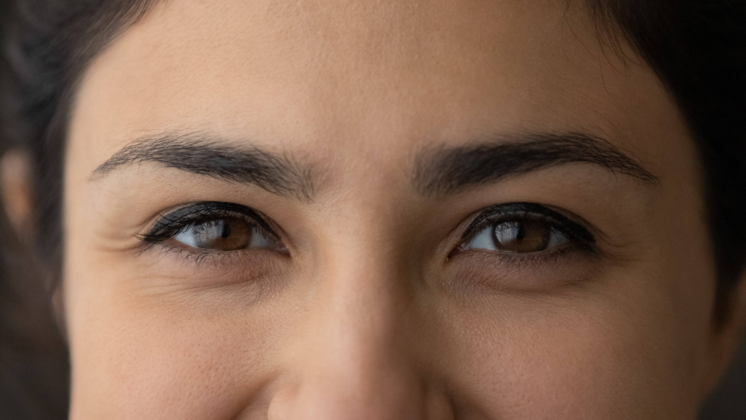 A close up of a woman's brown eyes.