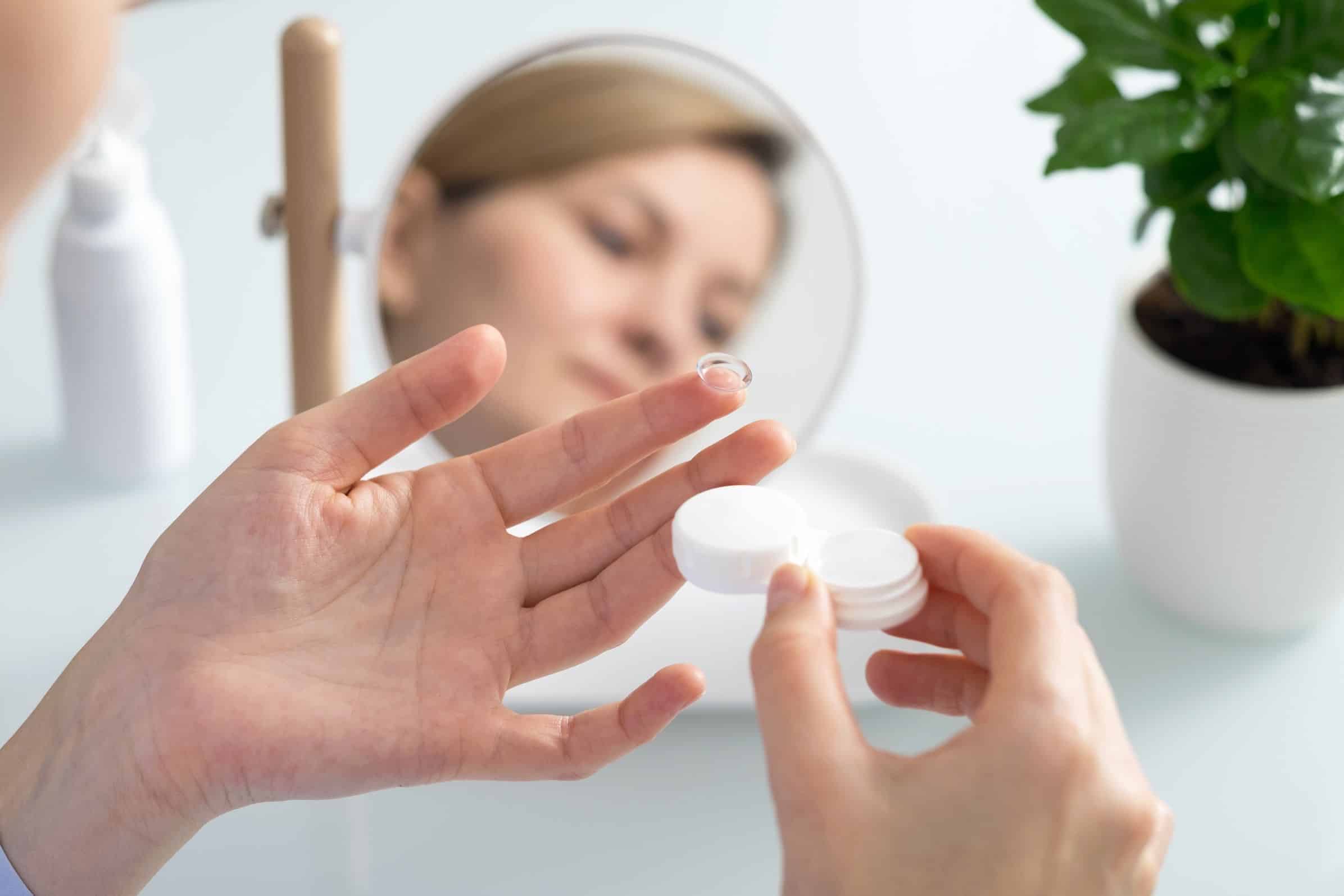 Woman with a contact lense on her finger ready to put it in