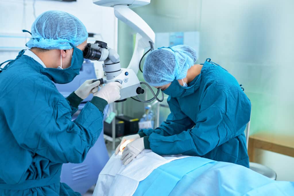 Eye surgery in progress with two medical professionals in scrubs